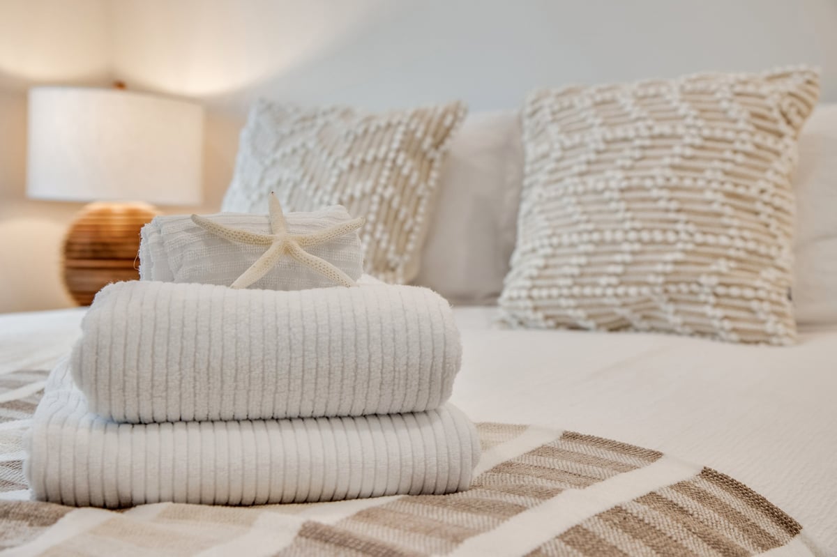 Fresh stack of clean towels ready for guests — vacation rental turnover service by A-List Cleaners