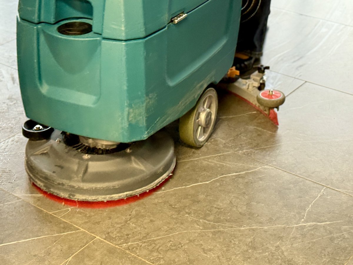 Industrial ride-on floor scrubber cleaning a corporate lobby — professional commercial cleaning at scale